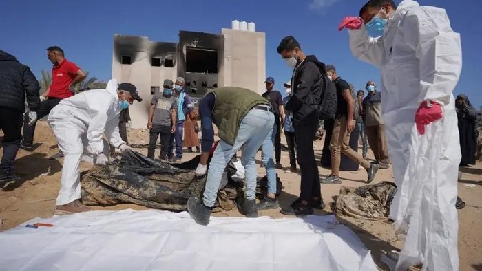 Pekerja medis mengumpulkan mayat yang digali dari kuburan di kompleks RS Al-Nasser di Jalur Gaza bagian selatan. (detikNews/AFP)