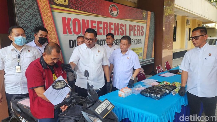 Antoni memperagakan saat dirinya hendak menurunkan sabu dari motor lalu ditangkap polisi. (Detikcom )